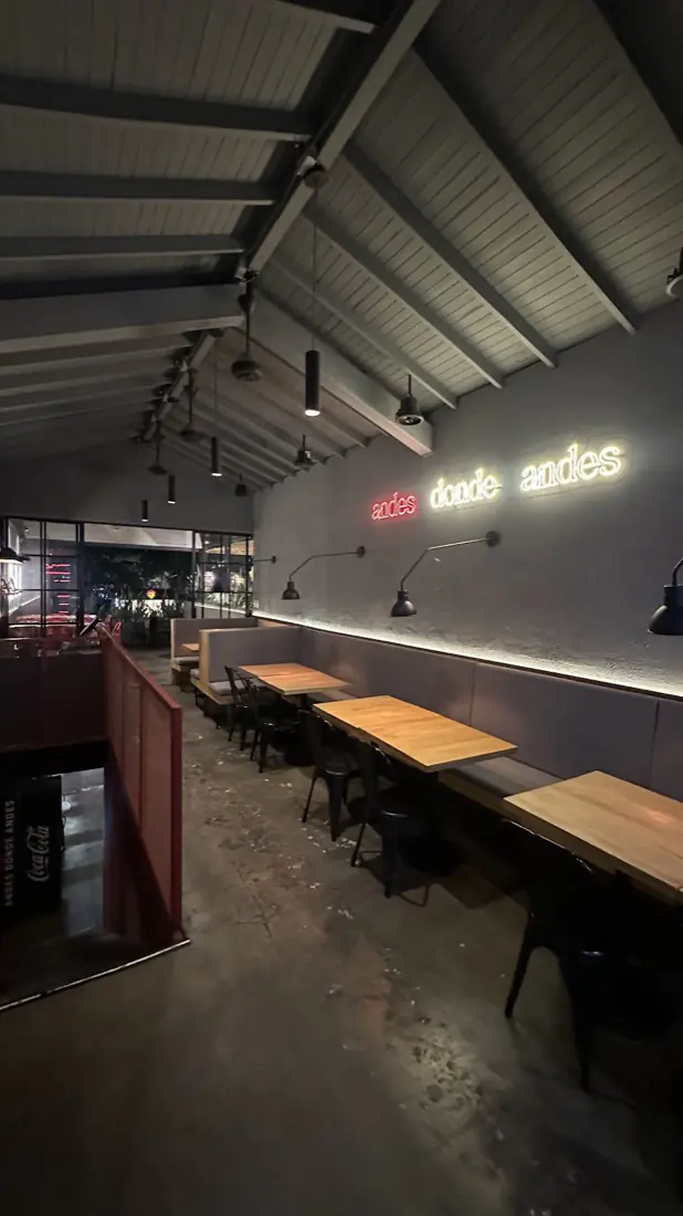 Interior de Andes Burger con barra, mesas de madera y luces